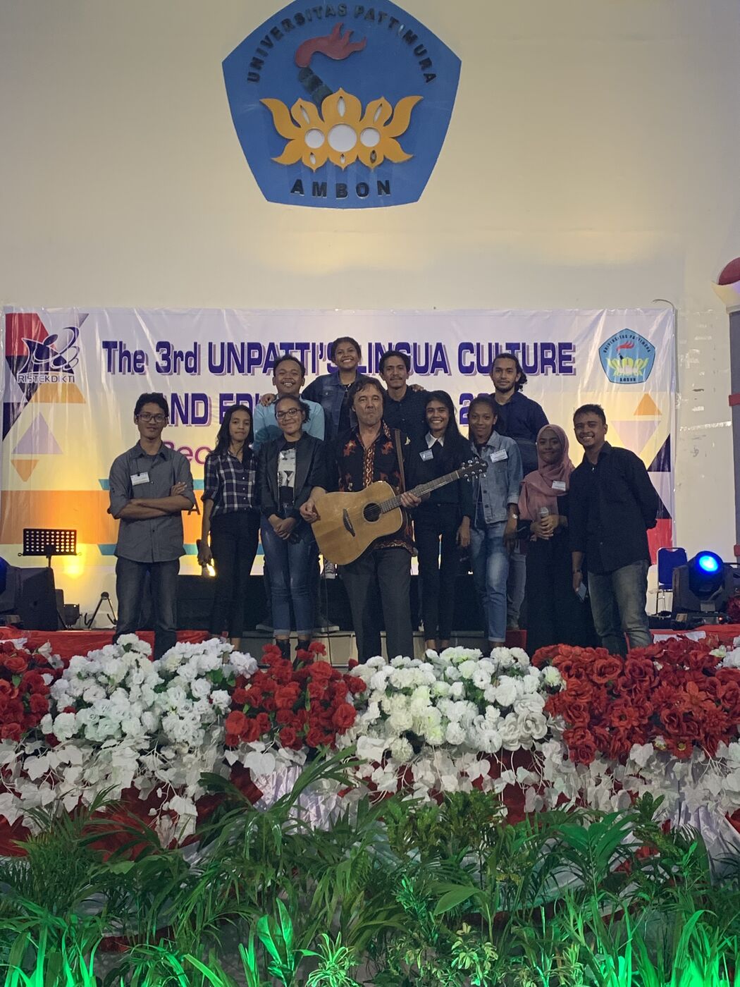 Markus Aerni mit Gitarre und Studierenden auf der Bühne der Universität Pattimura in Ambon