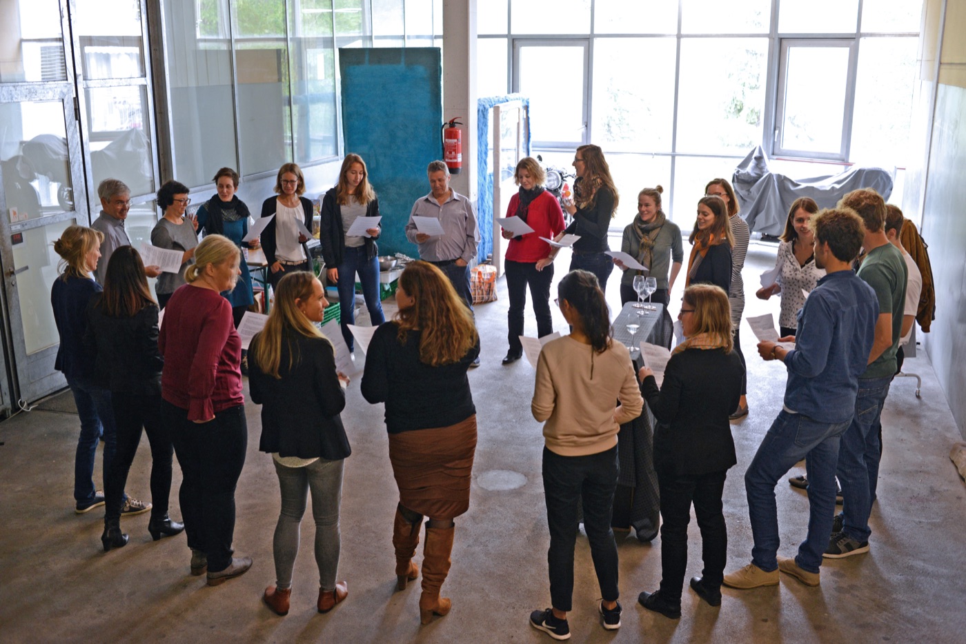 Ein Team steht im Kreis und singt vom Blatt