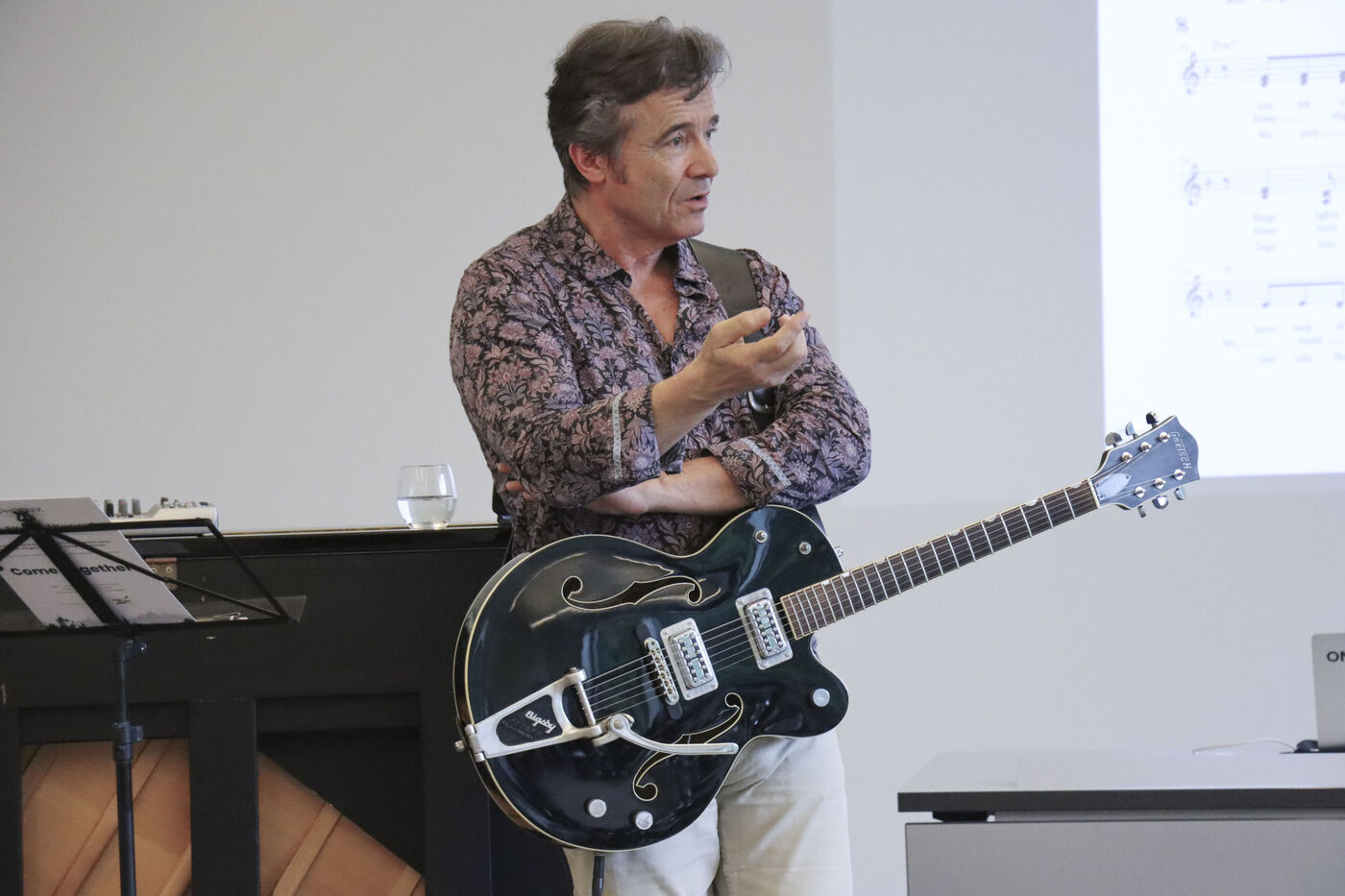 Markus Aerni mit Gitarre erklärt dem Kader den Song