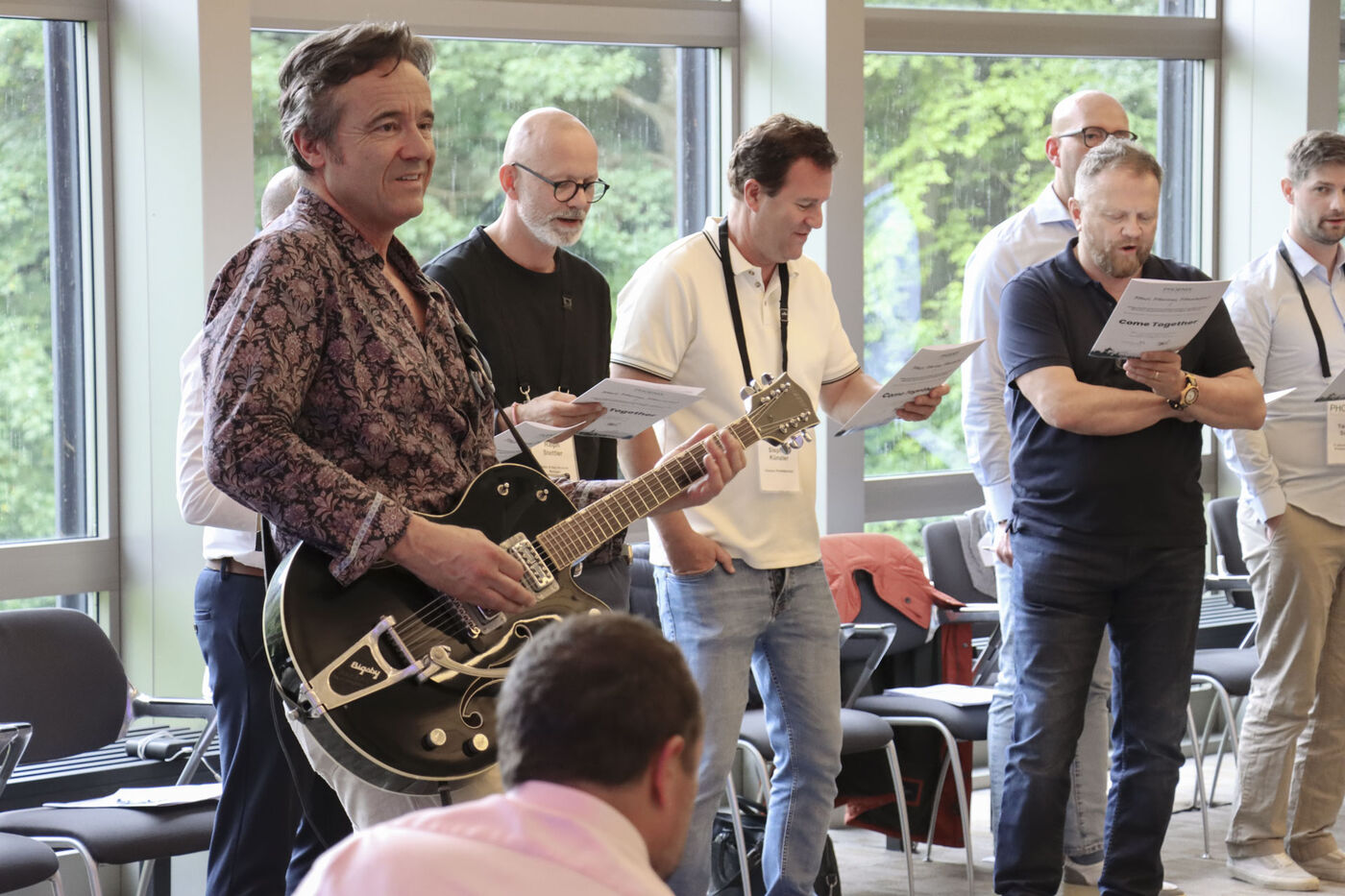 Markus Aerni begleitet auf der Gitarre eine Gruppe, die vom Blatt singt